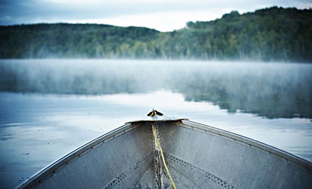The view from a small boat on a misty lake.