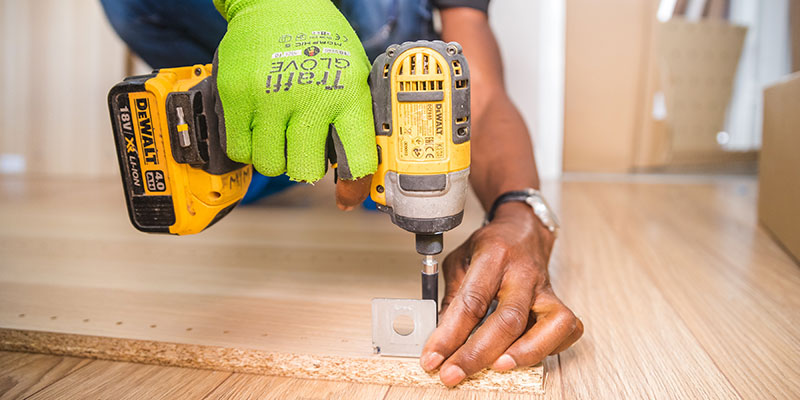 Person using a drill doing home building work.