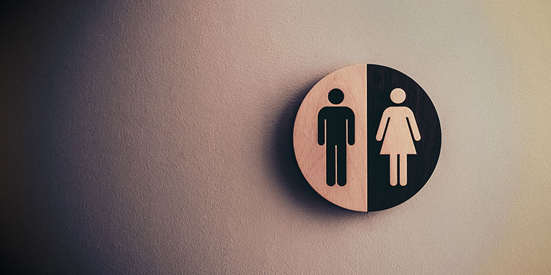 A public washroom sign hangs on a door.